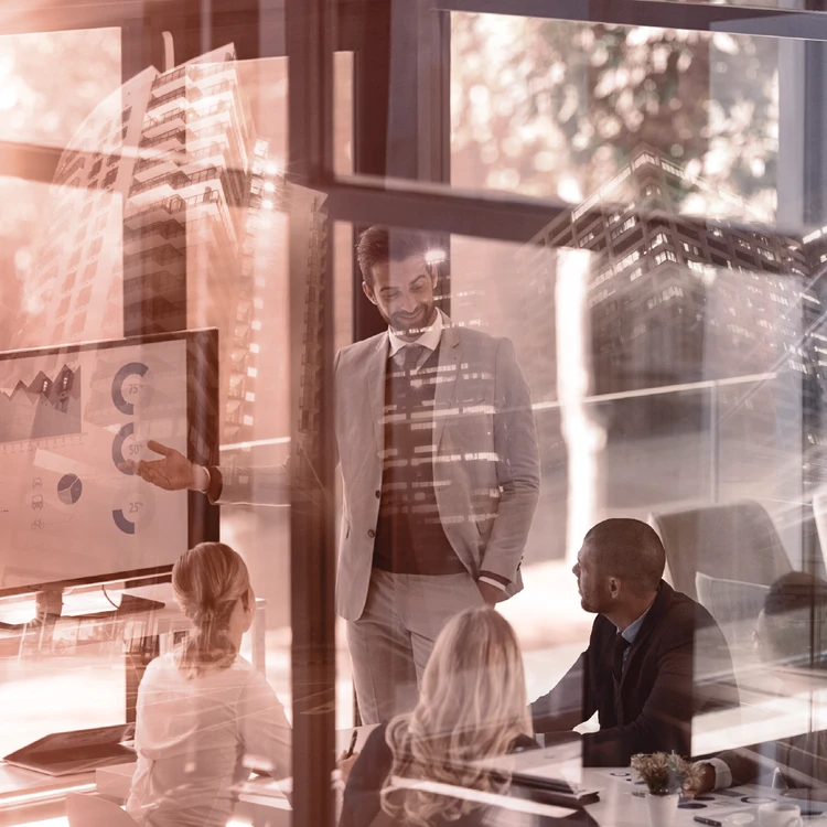 A senior consultant presents data and market analysis to an executive team in a boardroom, highlighting expertise and strategic positioning.