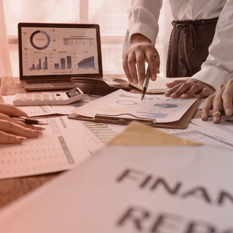 Management consultants examine financial reports and charts using a data-driven approach for strategic analysis and execution in highly complex financial services.