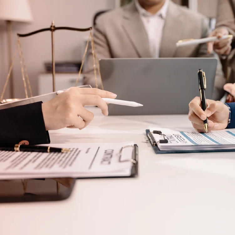 Legal and compliance consultants reviewing documents and contracts for DORA, NIS2, and AI Act regulatory compliance.