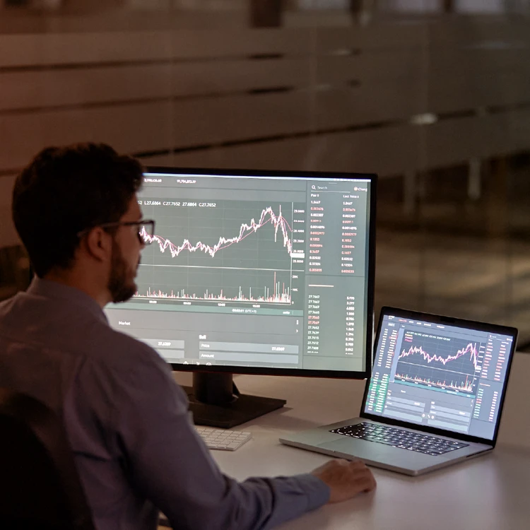 Analyst monitoring data and charts at computer using an operational risk management platform.