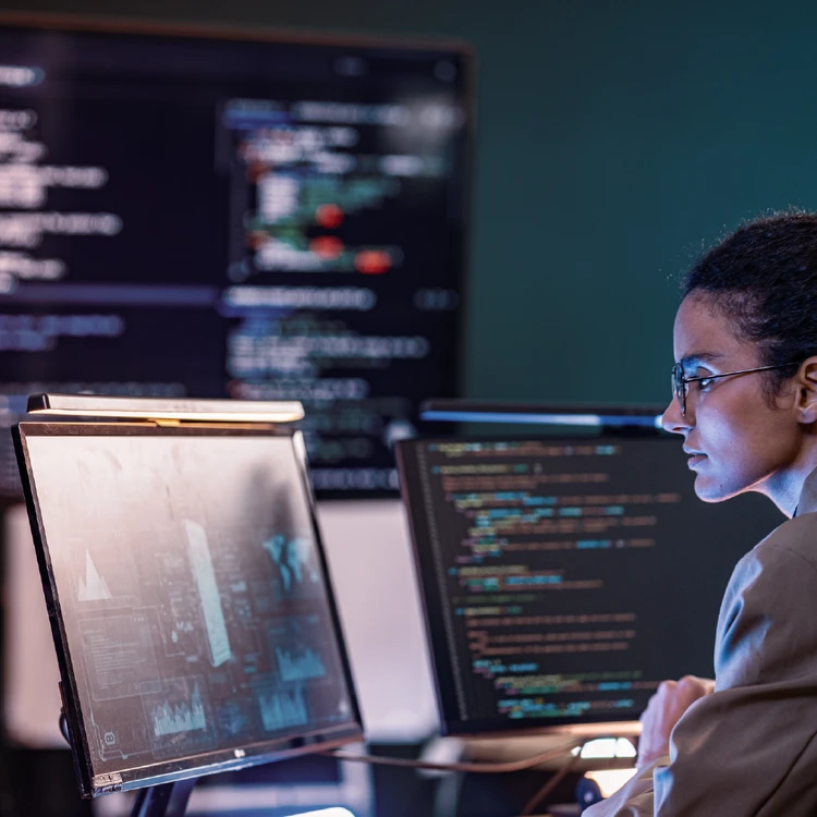 An expert analyzing complex data systems and code across multiple screens, symbolizing compliance within the Regulatory & Supervisory Framework.
